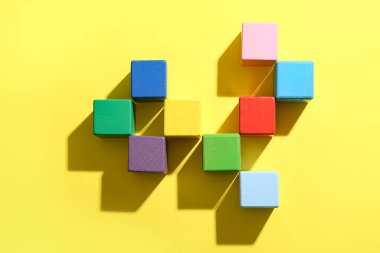 Sarı zemin üzerinde renkli yapı küpleri olan kompozisyon