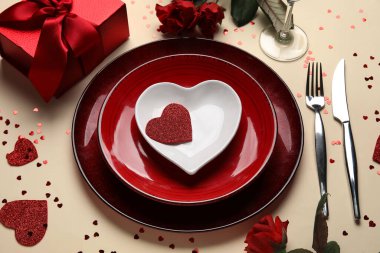 Hediye kutusu, kalpler ve sarı arka planda kırmızı güller olan güzel bir masa. Sevgililer Günü kutlaması