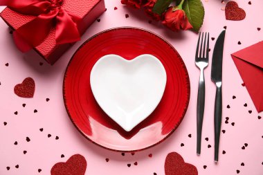 Hediye kutusu, kalpler ve pembe arka planda kırmızı güller olan güzel bir masa. Sevgililer Günü kutlaması