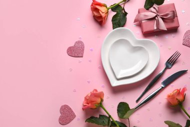 Hediye kutusu ve pembe arka planda güzel güller olan şık bir masa. Sevgililer Günü kutlaması