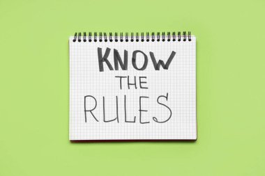 Yeşil arkaplandaki kuralları bilen metin içeren defter