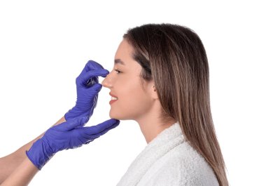 Güzel genç bir kadın ve kozmetikçinin elleri beyaz arkaplanda.