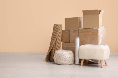 Taşınırken odada streç film ve karton kutularla paketlenmiş puflar