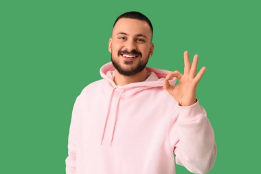 Genç adam yeşil arka planda iyi görünüyor. Kural kavramı