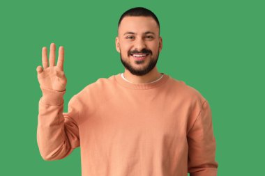 Yeşil arka planda üç parmağı olan genç bir adam. Kural kavramı