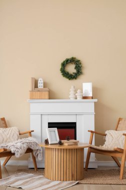 Koltukları, şöminesi ve Noel çelengi olan oturma odasının içinde.