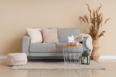 Oturma odasının içinde kanepe, otlaklar ve mum tutacakları var.