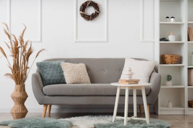 İçinde kanepe, raf ve Noel çelengi olan oturma odası.