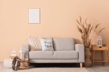 Oturma odasının içinde kanepe, masa ve Noel fenerleri var.