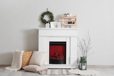 İçinde şömine ve Noel çelengi olan oturma odası.