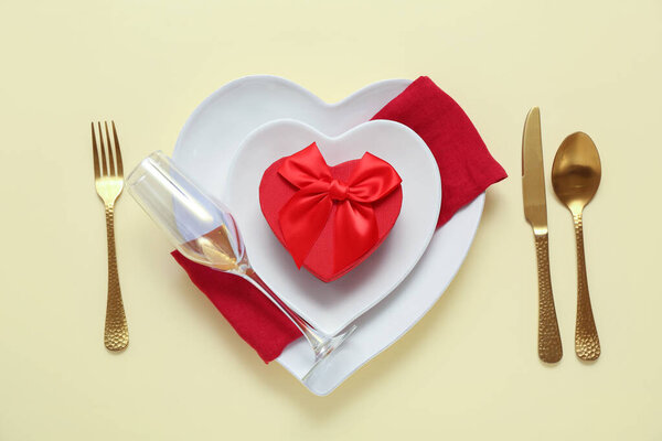 Стол с подарочной коробкой на желтом фоне. Празднование Дня Святого Валентина
