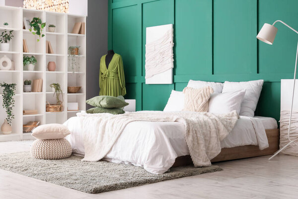 Интерьер спальни с полкой, зелеными растениями и манекеном