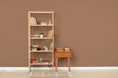 Oturma odasının içinde kitap olan ahşap masa ve raflar.