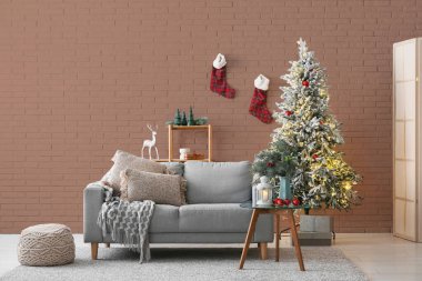 Gri kanepesi, Noel ağacı ve dekoru olan bir oturma odası.