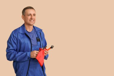 Bej arka planda araçları olan erkek tamircinin portresi