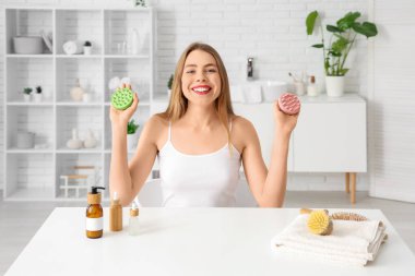 Evde saç tıraşı olan genç bir kadın var.