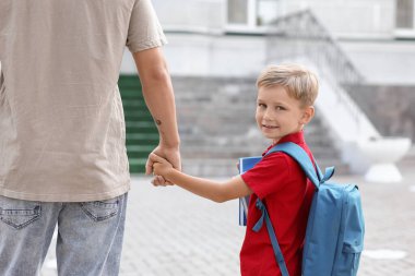 Baba küçük oğlunu okula götürüyor.