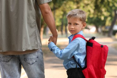 Baba küçük oğlunu okula götürüyor.