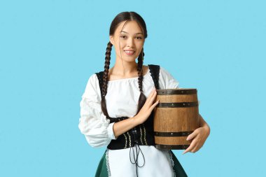 Genç Ekim Festivali garsonu mavi arka planda bir fıçı birayla