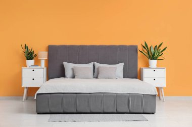 Rahat yatağı, komodinleri ve çiçekleri olan şık bir yatak odası.