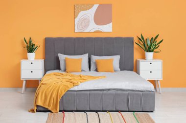 Rahat yataklı, komodinli, resimli ve çiçekli güzel bir yatak odası.