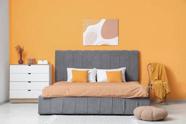 Rahat yatağı, çekmeceleri, sandalyesi ve ekoseli güzel yatak odası.