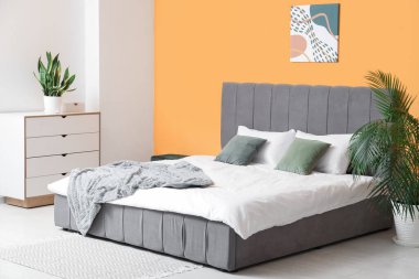 Güzel yatak odası, rahat yatak, çekmeceler, resim ve çiçek.