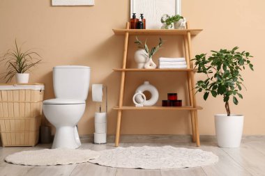 Tuvaletin içinde klozet, raf ünitesi ve çamaşır sepeti var.