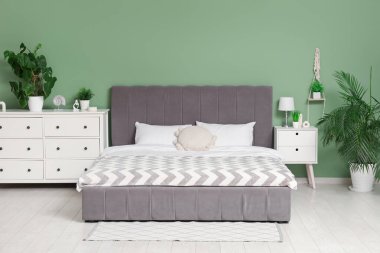 Yatağı ve çekmeceleri olan modern, rahat yatak odasının içi.