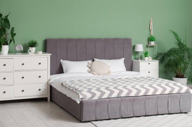 Yatağı ve çekmeceleri olan modern, rahat yatak odasının içi.