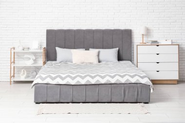 Şık bir yatak odası, yatak odası, çekmeceler, raf ünitesi ve lamba.