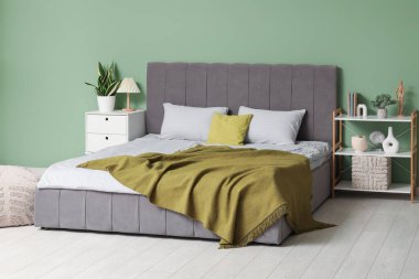 Yatağı, yatağı, yatağı ve rafları olan şık bir yatak odası.