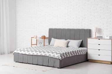 Şık bir yatak odası, yatak odası, çekmeceler, raf ünitesi ve lamba.