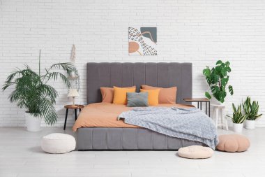 Yatak odası, çiçekleri ve komodinleri olan rahat bir oda.