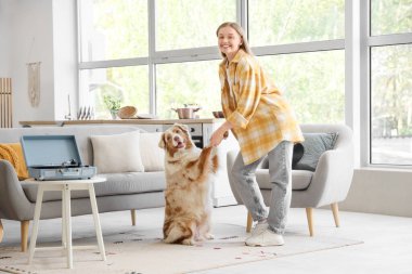 Avustralya çoban köpeği ve pikapıyla evde dans eden genç bir kadın.