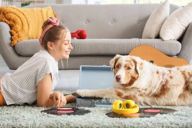 Avustralyalı çoban köpeği ve pikabı olan genç bir kadın evde halıda yatıyor.