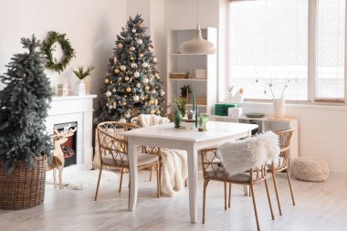 Masası, şöminesi ve Noel ağaçları olan hafif yemek odasının içi.