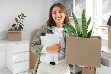 Taşındığı gün elinde kutu ve kağıtlarla genç bir iş kadını.