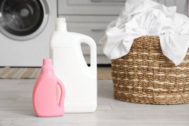 Çamaşır odasında çamaşır makinesinin yanında çamaşır sepeti ve çamaşır sepeti var.