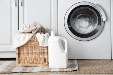 Çamaşır odasında çamaşır makinesinin yanında çamaşır sepeti ve çamaşır sepeti.