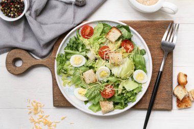 Lezzetli Sezar salatası ve beyaz ahşap arka planda bir kase biberli mısır.