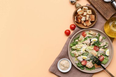 Lezzetli tavuklu Sezar salatası ve turuncu arka planda bir kase kızarmış ekmek.