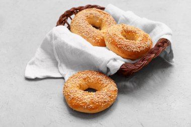Gri arka planda susam tohumlu bir sepet lezzetli simit.