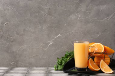 Portakallı, pipetli ve nane yapraklı bir bardak lezzetli meyve suyu.