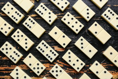 Siyah ahşap zemin üzerindeki beyaz domino taşlarının dokusu