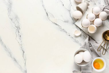 Beyaz arka planda çiğ tavuk yumurtası olan tutucu ve kase.