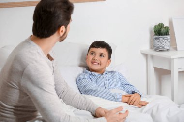 Babası ve küçük oğlu yatak odasında yatıyor.