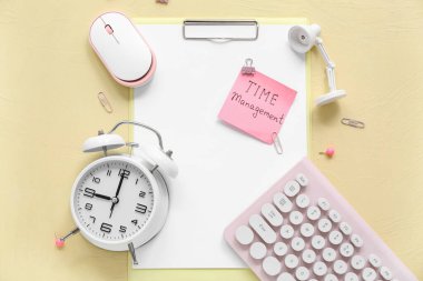 Renk arkaplanındaki text TIME MANAGEMENT, pano, alarm saati ve aygıtları içeren yapışkan bir not