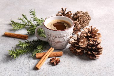 Köknar dallı çam kozalakları, tarçın ve beyaz arka planda bir fincan kahve.