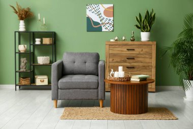 Koltuğu, sehpası ve yanan mumları olan modern oturma odasının içinde.